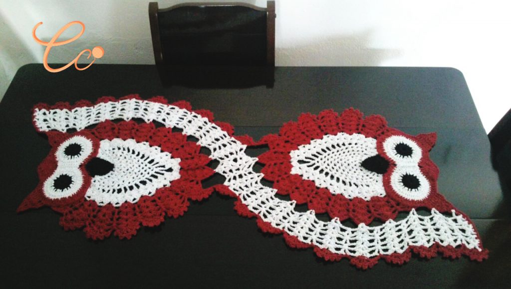 Caminho de mesa com barbantes em vermelho e branco no formato de corujas, decoração belíssima.